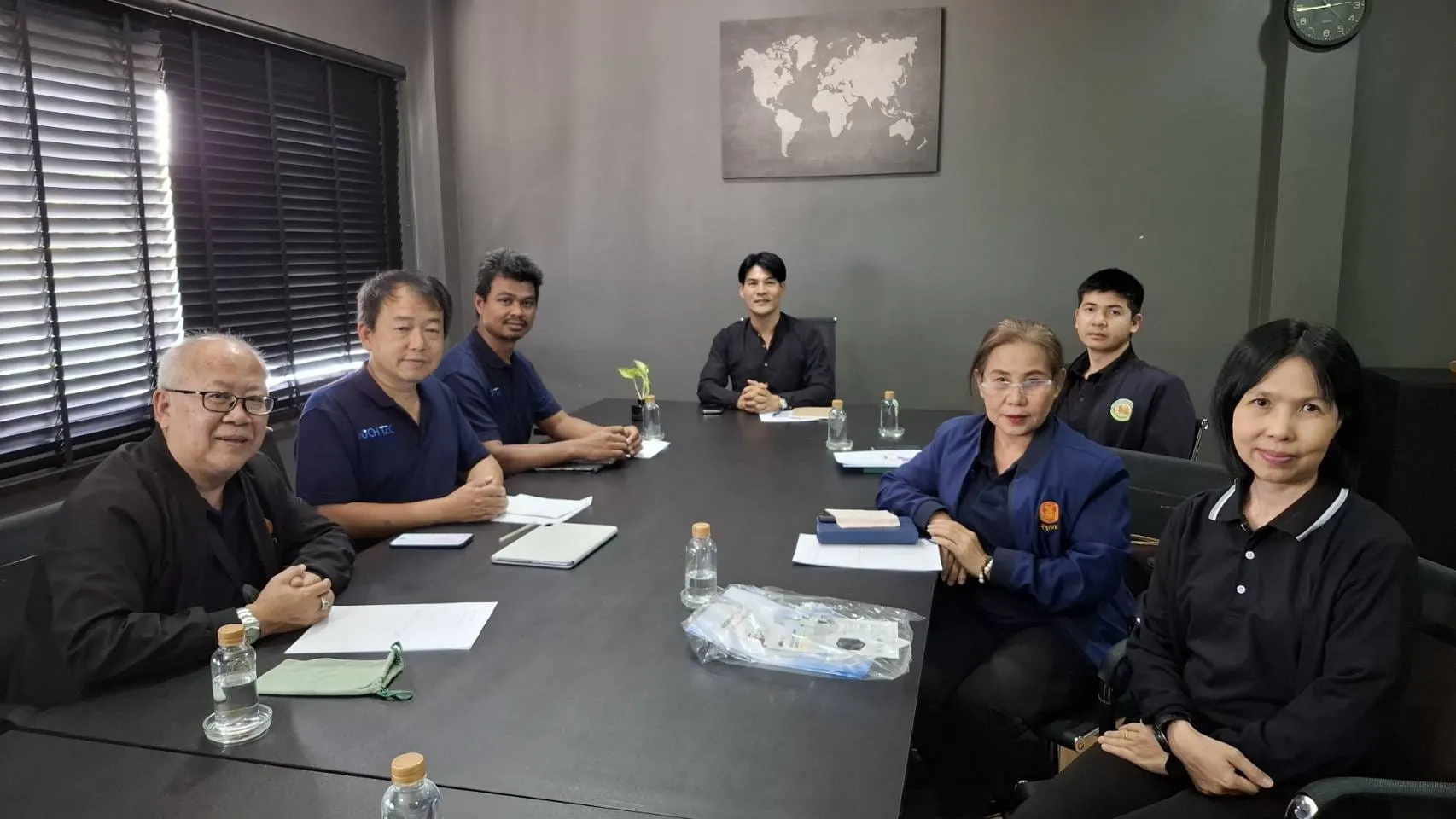 ทีม NICH TEC ในเสื้อโปโลสีกรมท่า ประชุมร่วมกับเจ้าหน้าที่เทศบาลตำบลดอนแก้วรอบโต๊ะประชุม